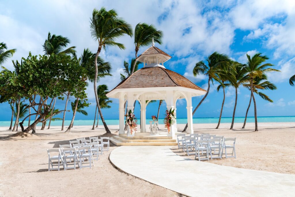 gazebo beach wedding ceremony with white chairs