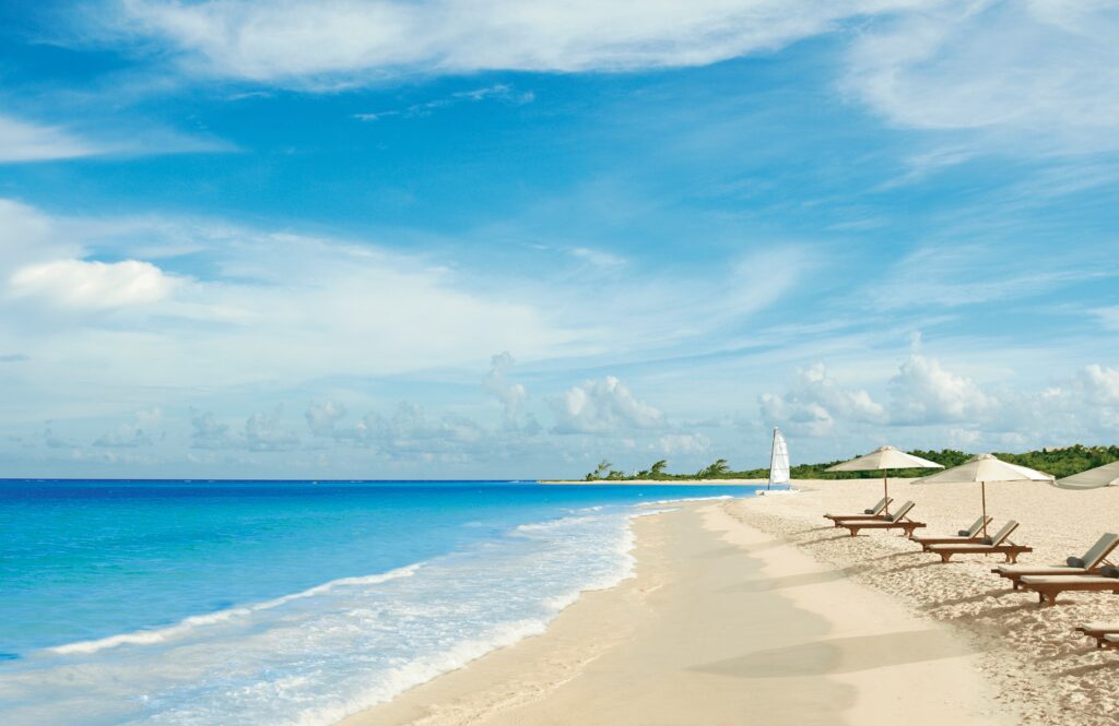 Secrets Maroma beach with umbrellas and loungers at the ocean