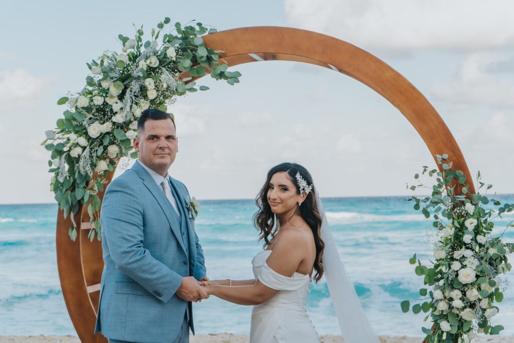 Beach wedding ceremony with circle wedding ceremony arch