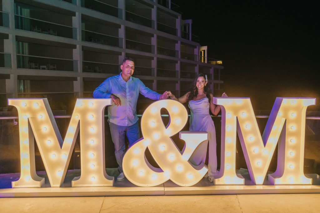 Bride & groom in front of marquee letters