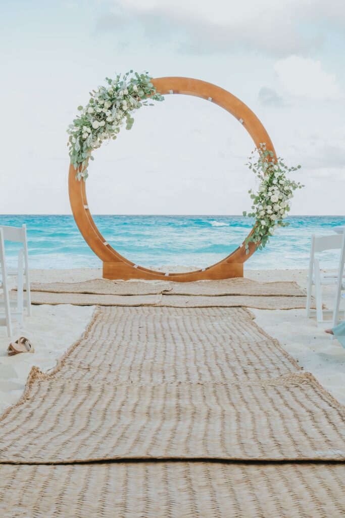 Beach wedding ceremony with circle wedding ceremony arch