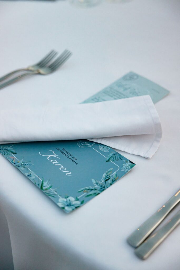 white wedding table with blue place card and blue menu