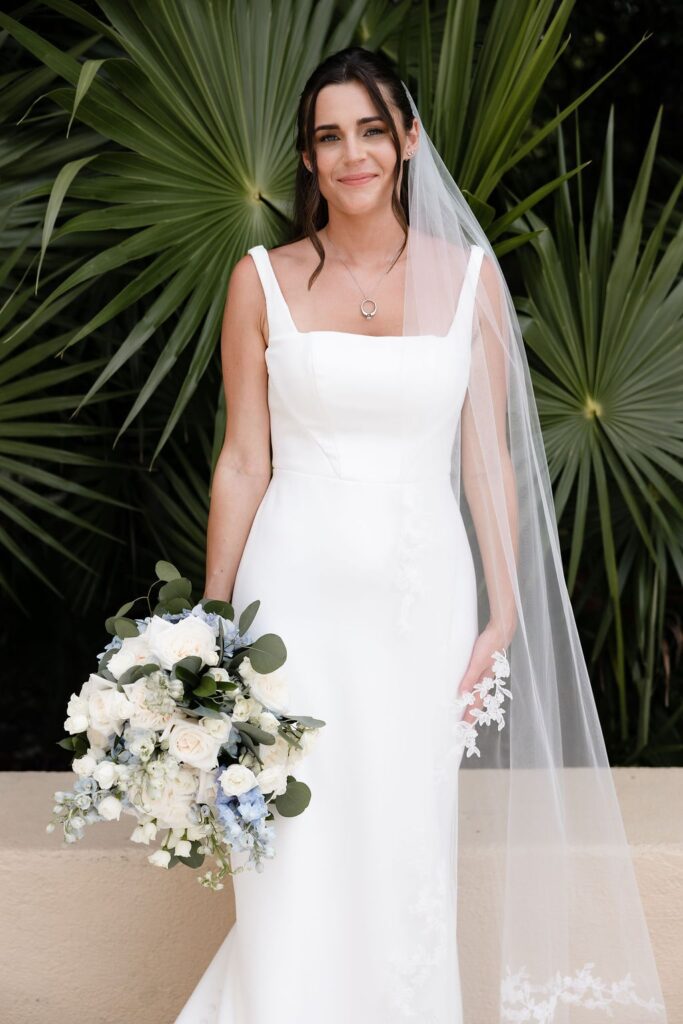 bride holding blue and white bridal bouquet