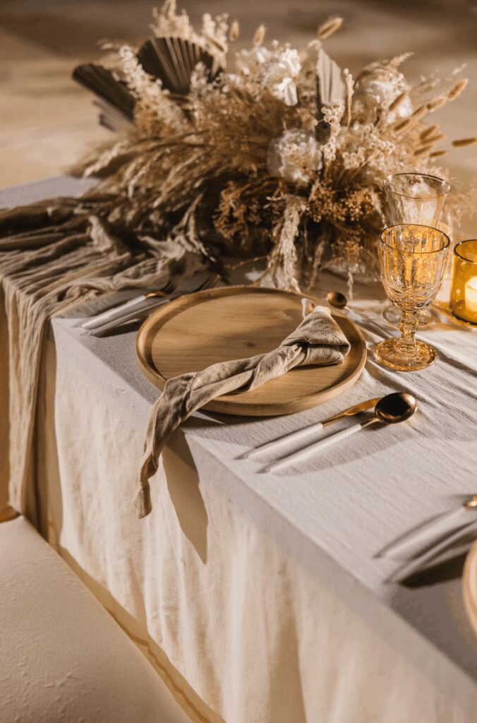 Boho wedding table setting with khaki table cloths and wood chargers at a UNICO 20°87° Hotel Riviera Maya wedding