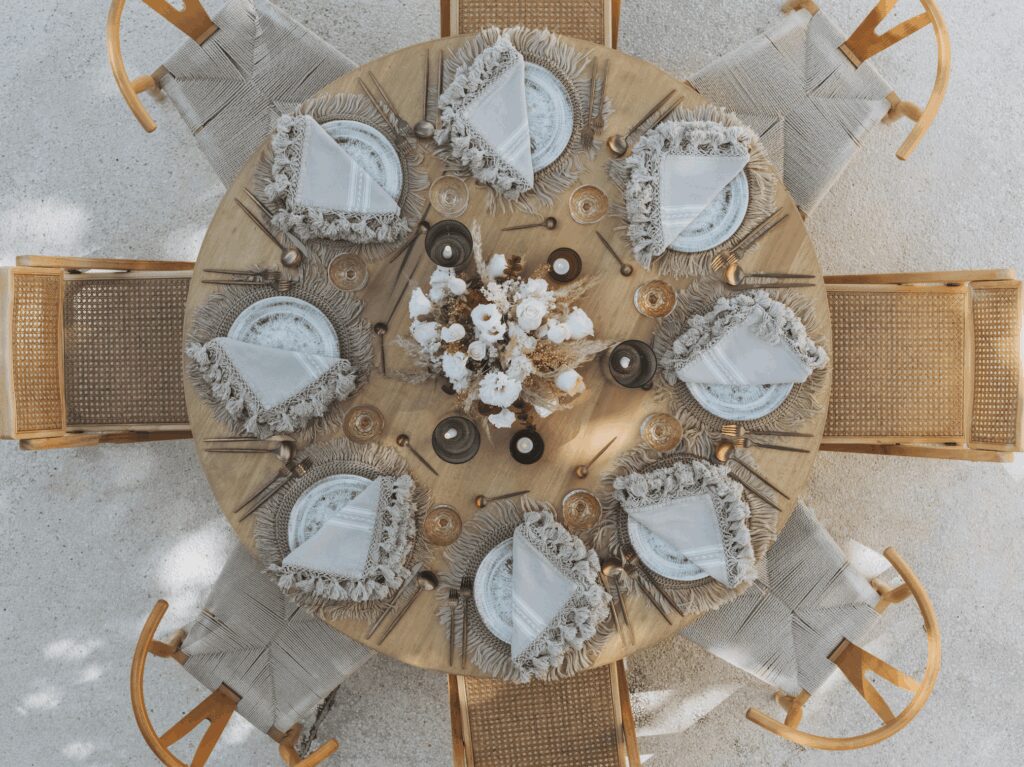 Aerial view of a wedding table with whicker chairs and neutral wedding table decor