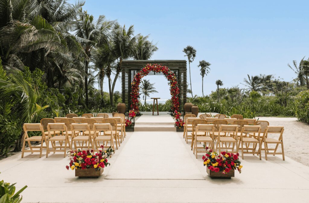 Outdoor wedding ceremony with bright flowers at UNICO 20°87° Hotel Riviera Maya