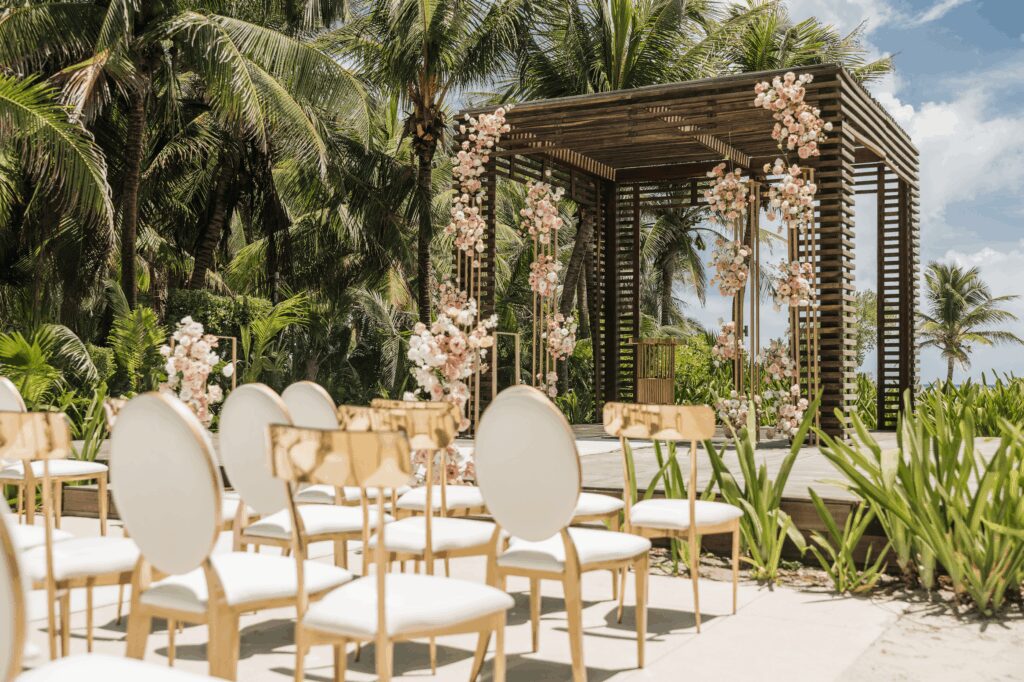 Gold and white chairs at an outdoor wedding ceremony at UNICO 20°87° Hotel Riviera Maya