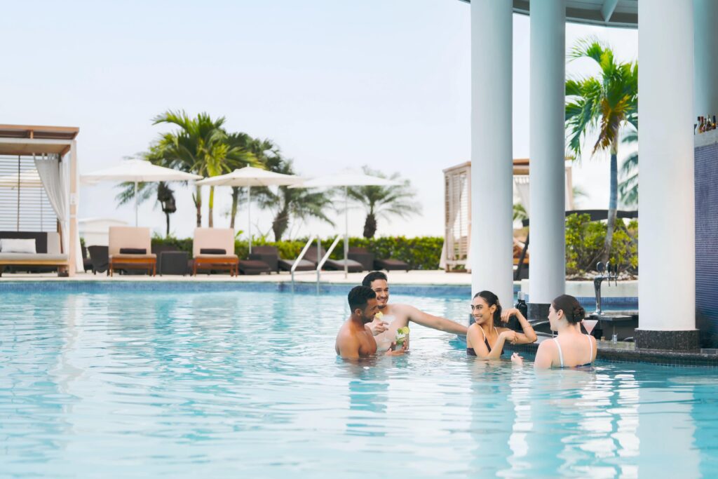 Adults socializing at a swim up bar at an adults only All-Inclusive resort