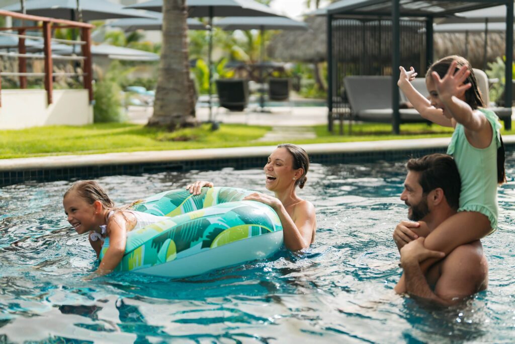 Families playing in the pool with tubes at a family friendly All-Inclusive resort