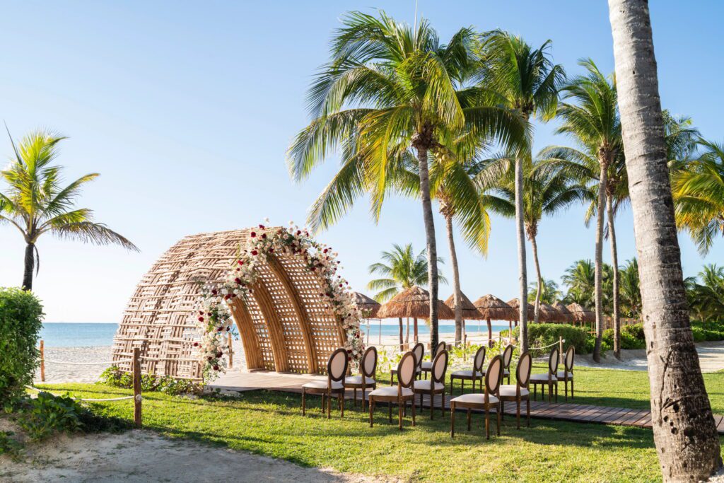 all inclusive resort wedding ceremony under bamboo altar with beach backdrop