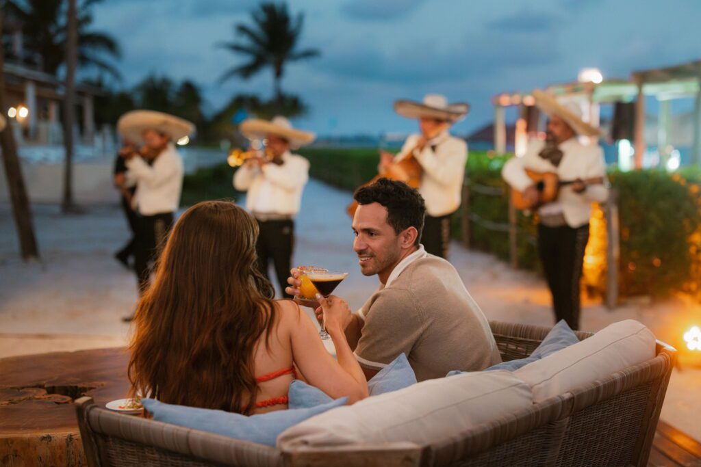 Wedding guests drinking cocktails in front of a mariachi band