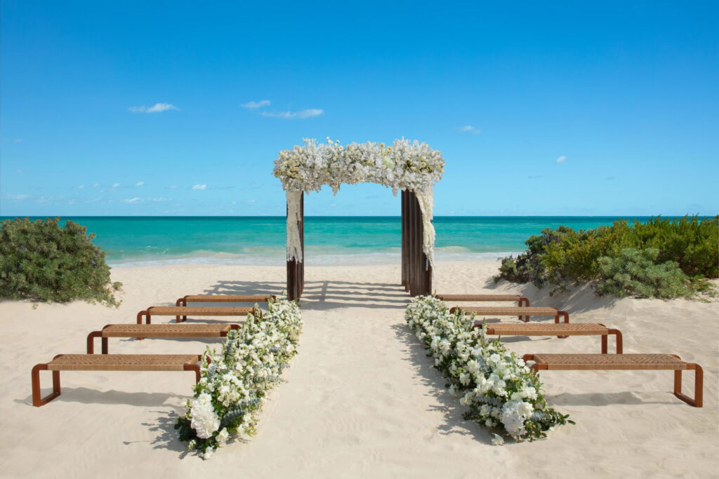 Mexico destination wedding on the beach with wood benches & wood altar