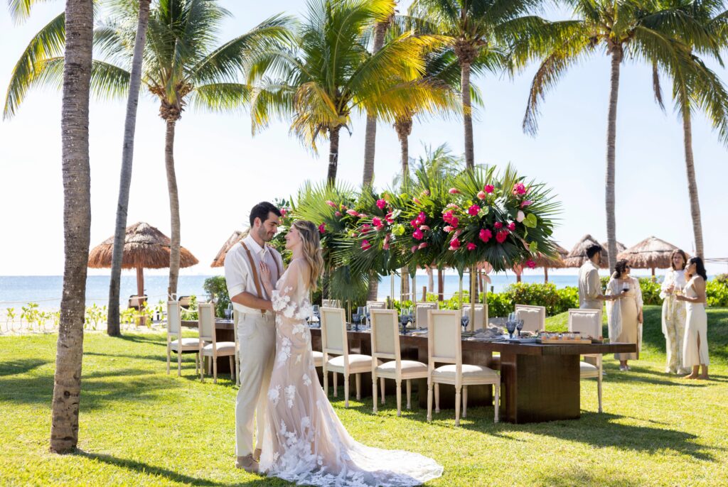 Bride & groom pose in front of an outdoor wedding reception table with a small wedding guest count