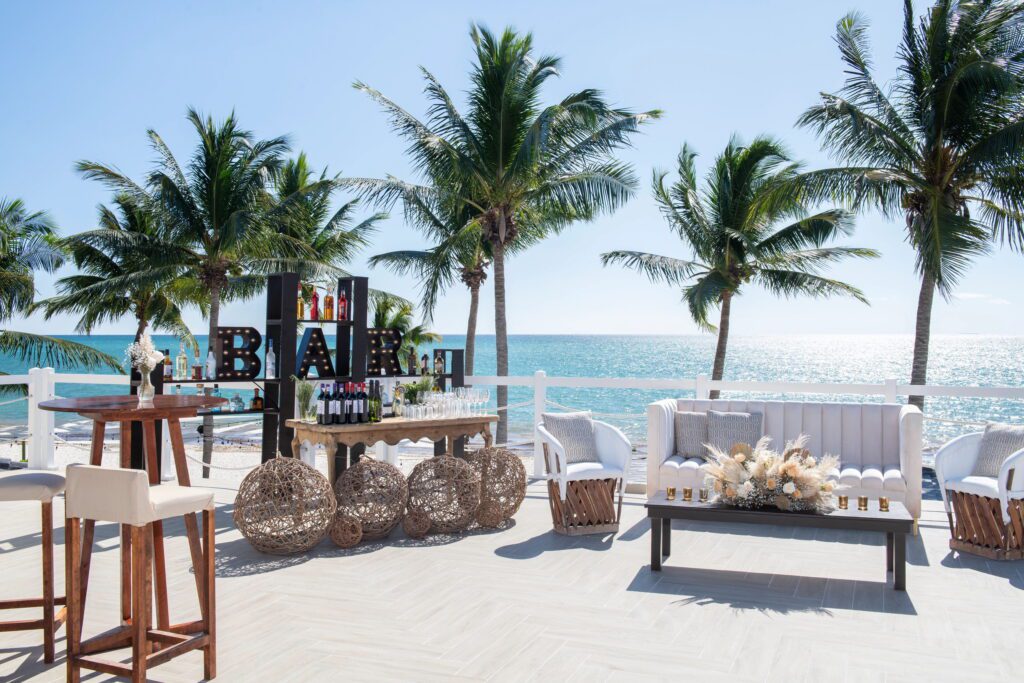 Outdoor wedding reception with palm trees & white sofas
