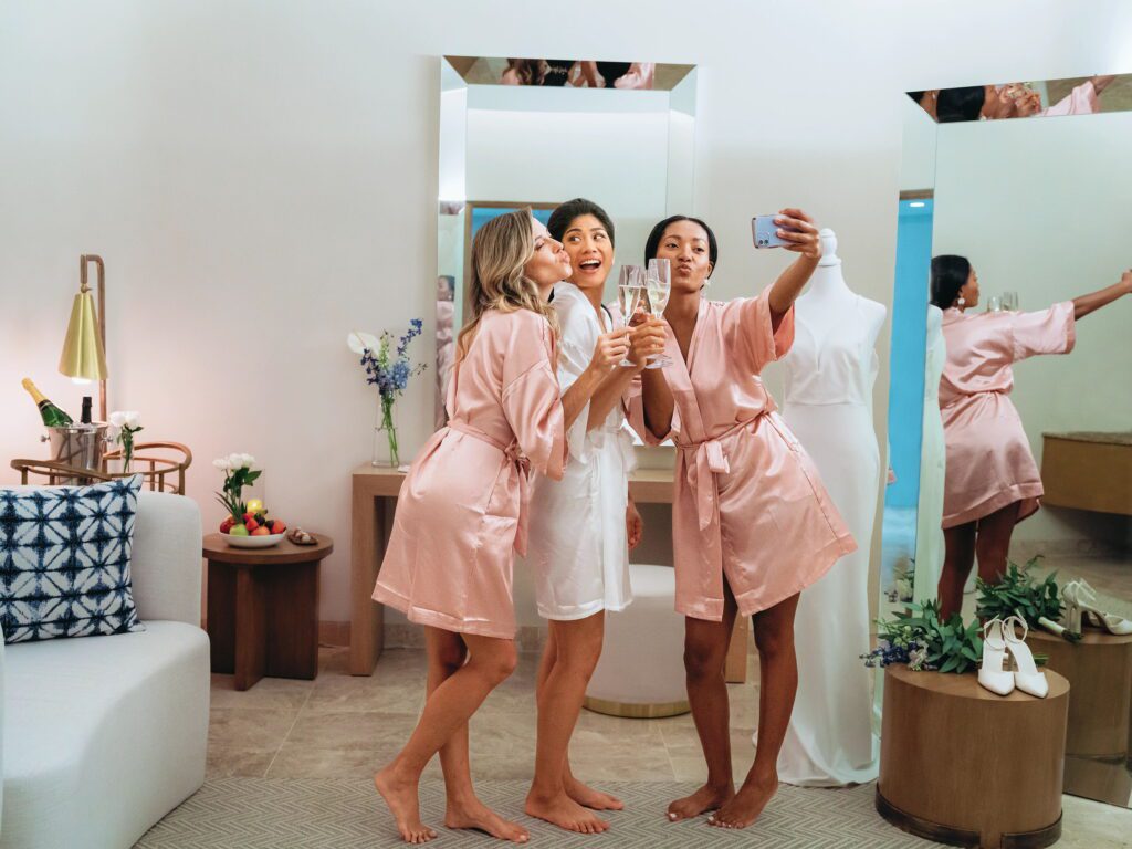 Bride & bridesmaids taking a selfie in satin robes
