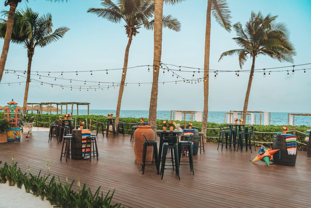 Outdoor wedding reception with palm trees & cocktail tables