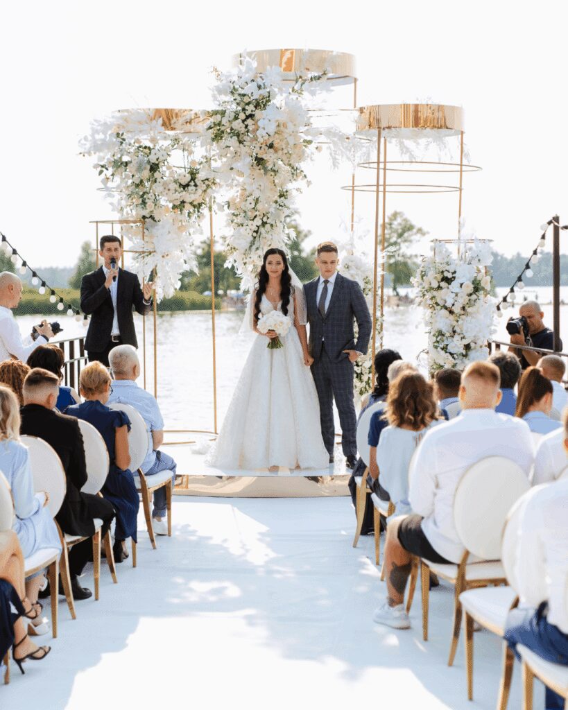 Large destination wedding ceremony with luxurious white and gold wedding ceremony decor