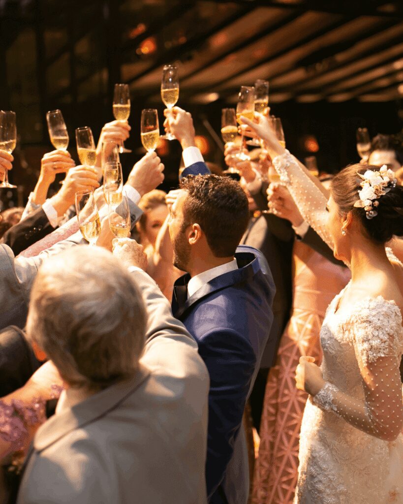 Large destination wedding guests cheersing drinks