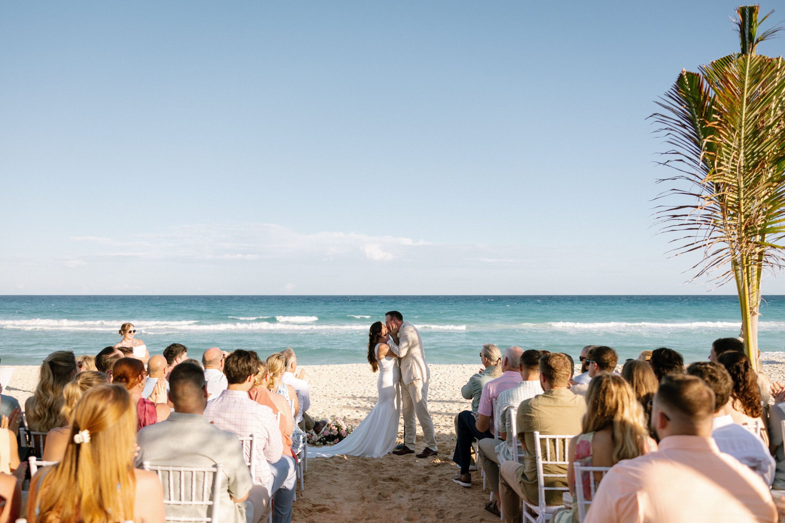 Newlyweds share a first kiss during their beach wedding ceremony at Live Aqua Cancun North Beach